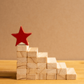 Photo shows the building blocks that look like stairs that reach toward a star at the top, representing how the steps to build a great compensation philosophy are chosen carefully and thoughtfully.
